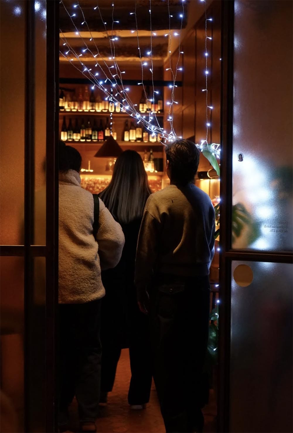 L'entrée du Barrique un soir, guirlandes lumineuses et clients